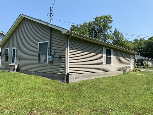 view of home's exterior with cooling unit and a yard