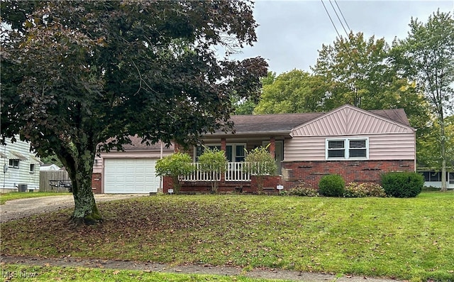 view of front of house with a garage, a front lawn, and covered porch