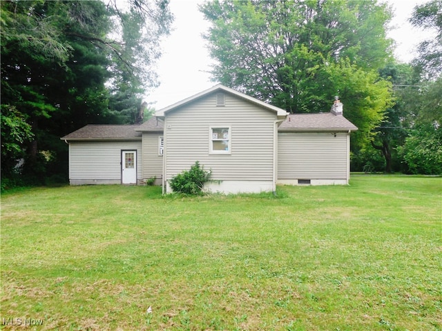 back of property featuring a lawn