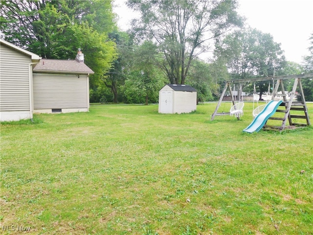 view of yard featuring a storage unit and a playground