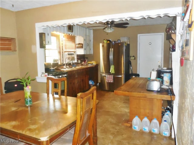 dining area featuring ceiling fan and sink