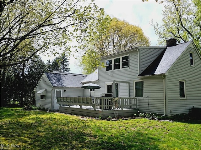 back of house featuring a wooden deck and a yard