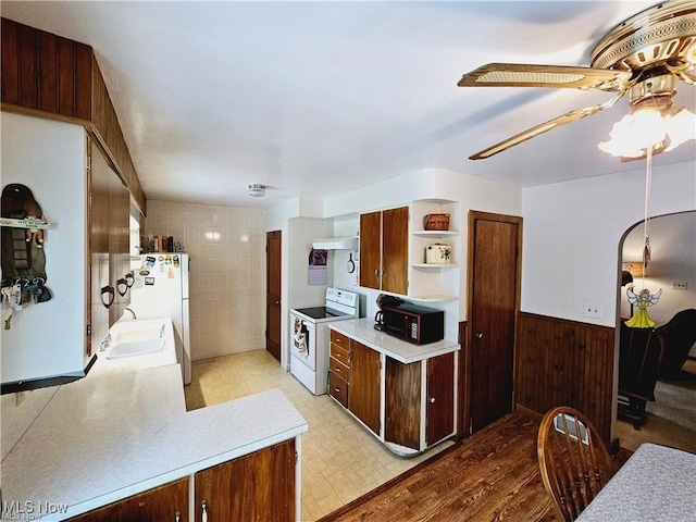 kitchen with tile walls, white appliances, ceiling fan, sink, and extractor fan