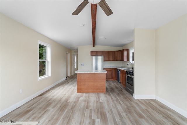 kitchen with light hardwood / wood-style floors, a center island, sink, vaulted ceiling with beams, and appliances with stainless steel finishes