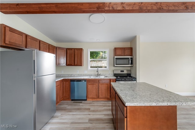 kitchen featuring beam ceiling, sink, stainless steel appliances, a center island, and light wood-type flooring