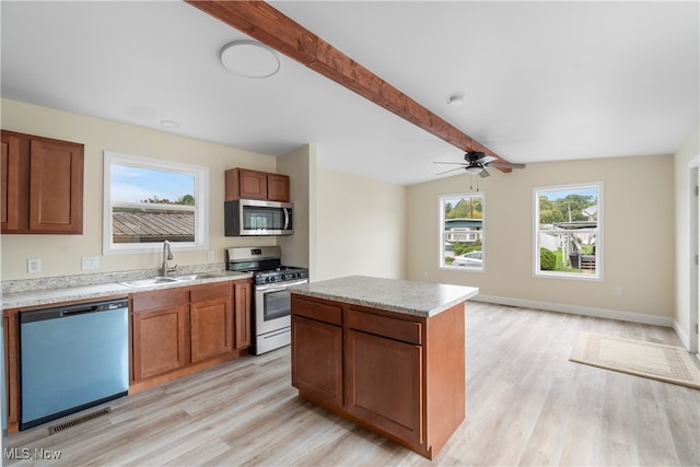 kitchen with a center island, sink, light hardwood / wood-style flooring, appliances with stainless steel finishes, and ceiling fan