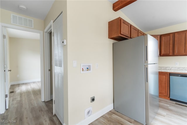 kitchen featuring appliances with stainless steel finishes, vaulted ceiling with beams, and light wood-type flooring