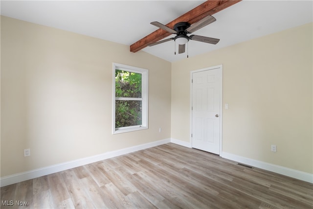 spare room featuring ceiling fan, vaulted ceiling with beams, and light wood-type flooring