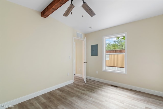 empty room with ceiling fan, electric panel, light hardwood / wood-style flooring, and lofted ceiling with beams