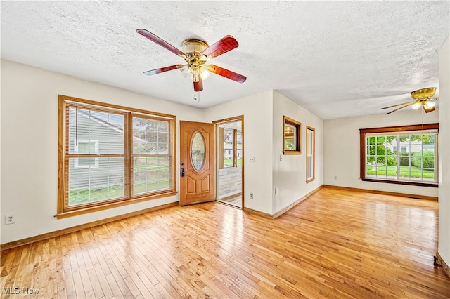 entryway with light wood-type flooring, a textured ceiling, and ceiling fan