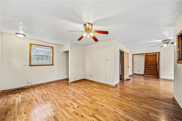 empty room featuring light wood-type flooring, a textured ceiling, and ceiling fan