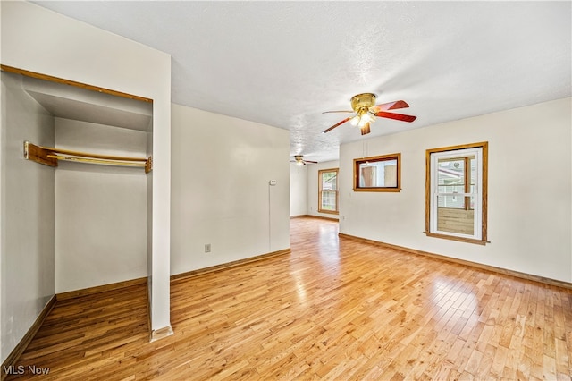 unfurnished living room with light wood-type flooring, ceiling fan, and a textured ceiling