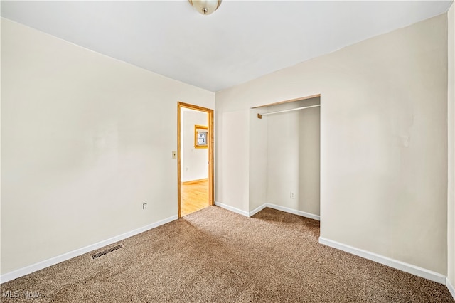 unfurnished bedroom featuring carpet and a closet