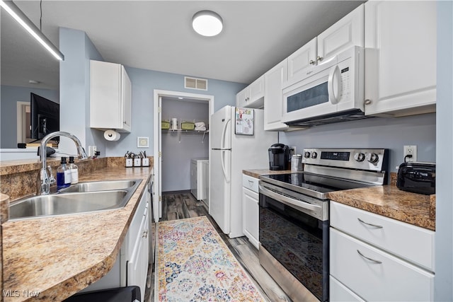 kitchen with white cabinets, sink, dark wood-type flooring, and white appliances