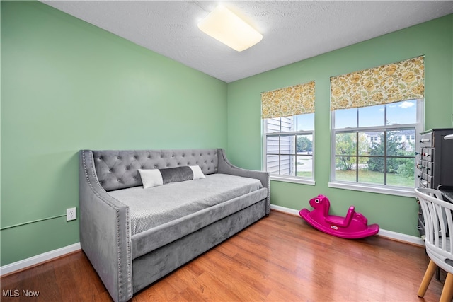 bedroom with a textured ceiling and hardwood / wood-style floors