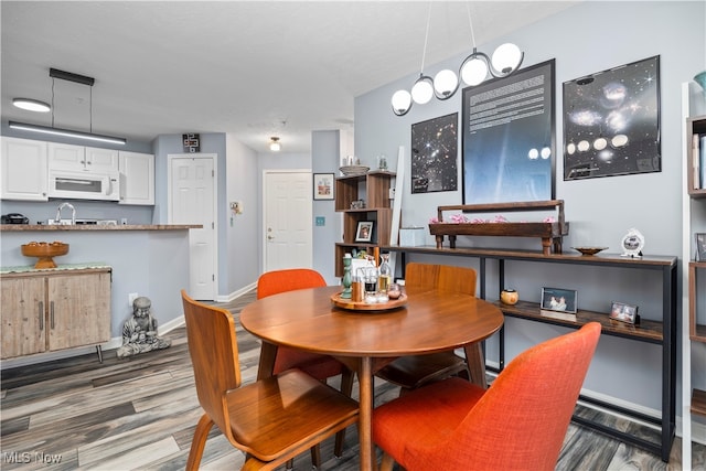 dining space with hardwood / wood-style floors and sink