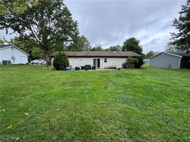 back of property with a patio, a yard, and central air condition unit