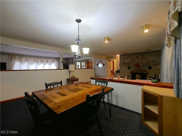 carpeted dining area featuring a notable chandelier and a fireplace