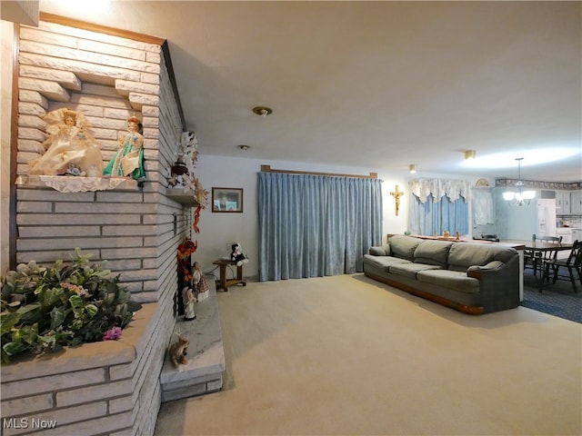 living room with a notable chandelier, a fireplace, and carpet flooring