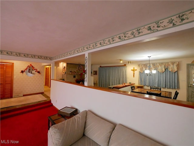 carpeted living room with an inviting chandelier