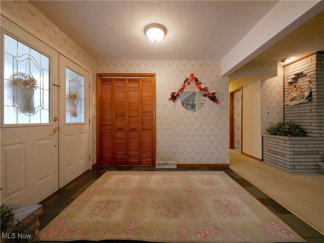 entryway with dark colored carpet