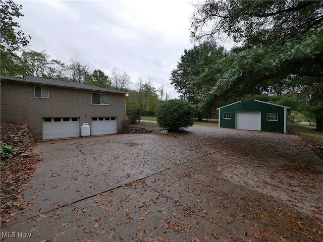 view of property exterior with a garage and an outbuilding