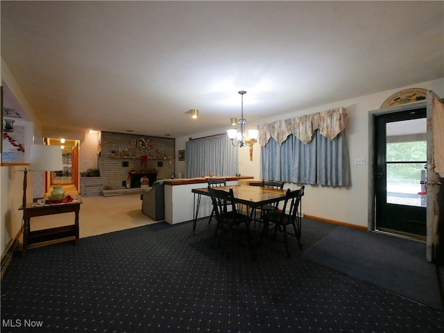 dining area with a brick fireplace, an inviting chandelier, and carpet