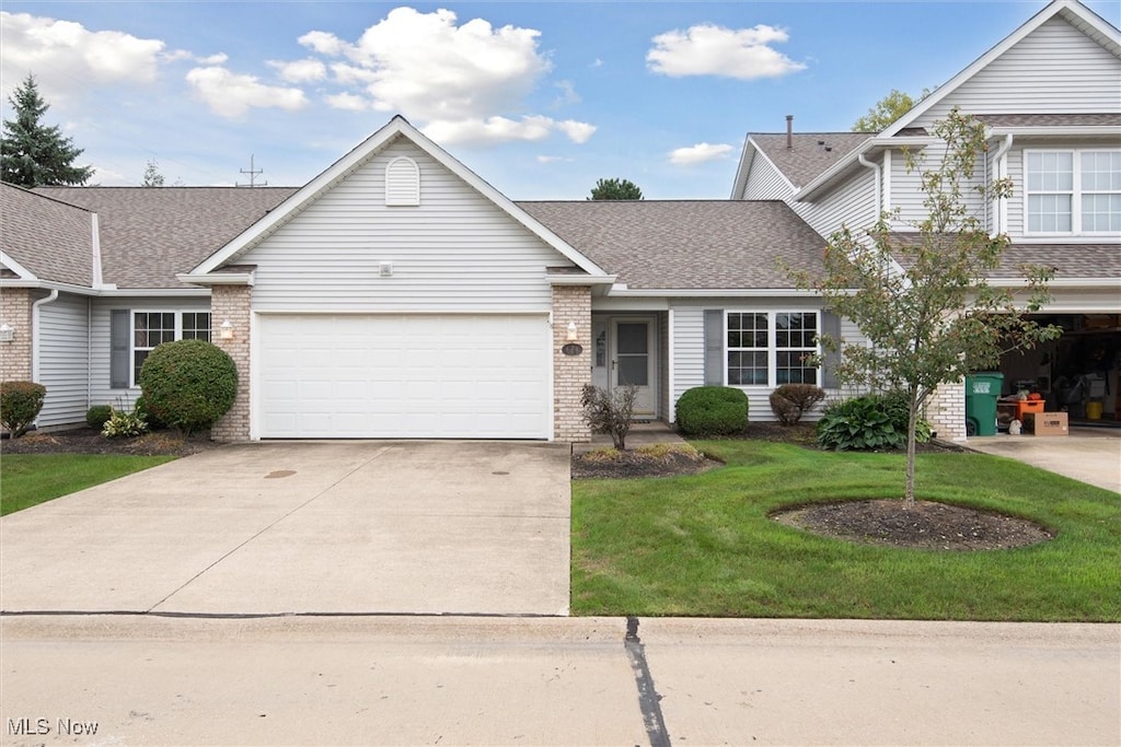 view of front of home with a garage and a front lawn