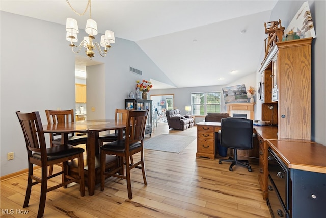 dining room featuring a notable chandelier, light wood-type flooring, and vaulted ceiling