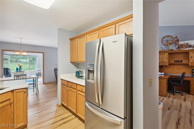 kitchen featuring built in desk, light hardwood / wood-style floors, a chandelier, stainless steel refrigerator with ice dispenser, and decorative light fixtures