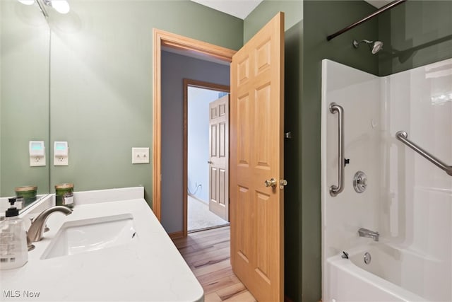 bathroom with wood-type flooring, shower / bathtub combination, and vanity