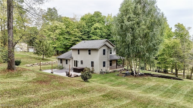 back of house with a lawn and a patio area