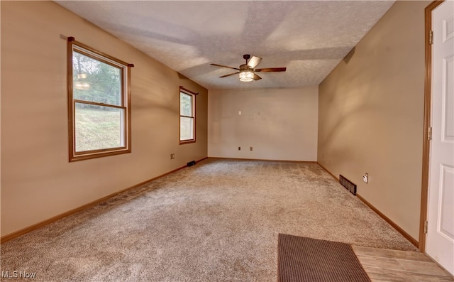 carpeted empty room featuring a textured ceiling and ceiling fan