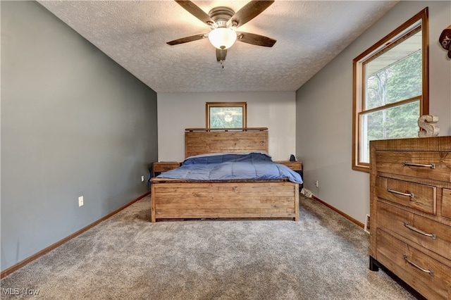 carpeted bedroom featuring a textured ceiling, ceiling fan, and multiple windows