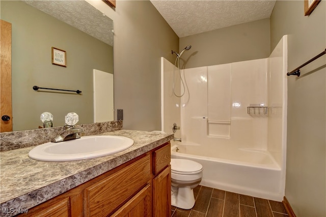 full bathroom featuring a textured ceiling, shower / washtub combination, vanity, and toilet