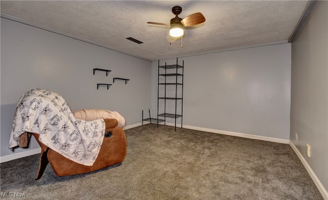 living area featuring ceiling fan, a textured ceiling, ornamental molding, and carpet