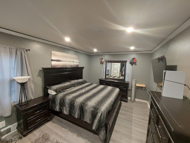 bedroom featuring light hardwood / wood-style flooring and ornamental molding