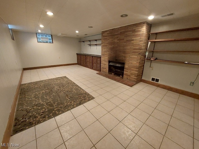 interior space featuring a large fireplace and light tile patterned floors