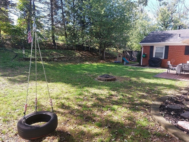 view of yard with a wooden deck and a fire pit