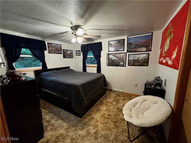 carpeted bedroom with ceiling fan and a textured ceiling