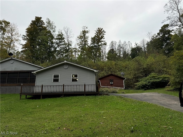 view of home's exterior featuring a lawn and a deck