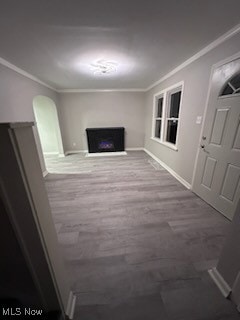 unfurnished living room featuring crown molding and hardwood / wood-style floors