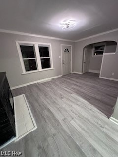 unfurnished living room with hardwood / wood-style floors and crown molding