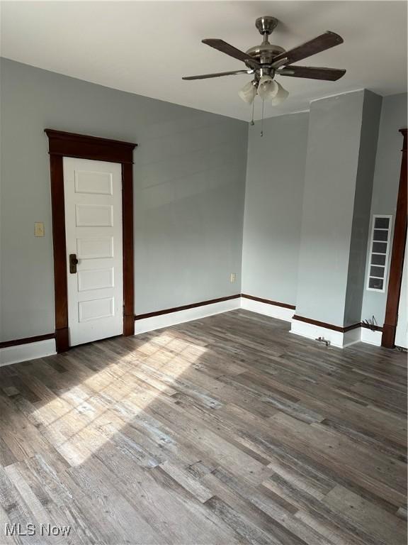 unfurnished room featuring visible vents, ceiling fan, wood finished floors, and baseboards