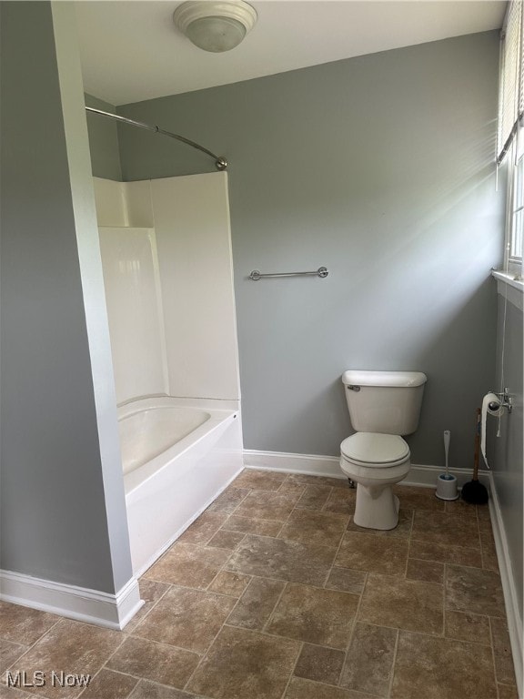 bathroom featuring bathtub / shower combination and toilet