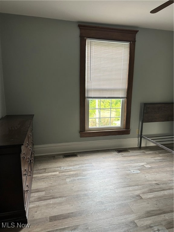 unfurnished bedroom featuring light wood-type flooring and ceiling fan