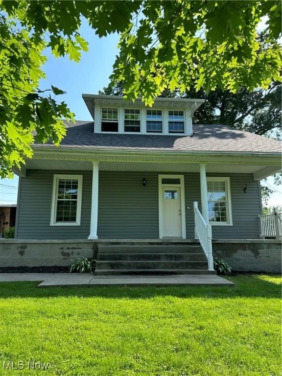 view of front of house with a porch, a shingled roof, and a front lawn