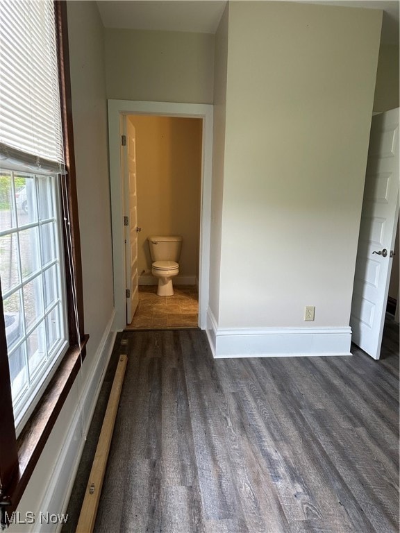 interior space with ensuite bath and dark hardwood / wood-style flooring