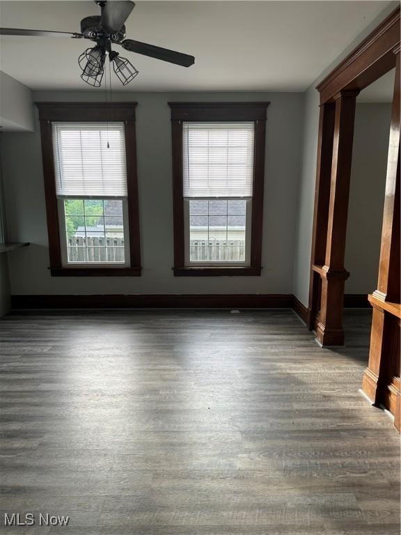 empty room with wood finished floors, ceiling fan, and baseboards