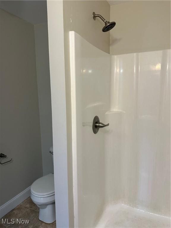 full bath with toilet, tile patterned floors, walk in shower, and baseboards